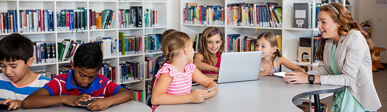 Photo of teacher and students in a library.